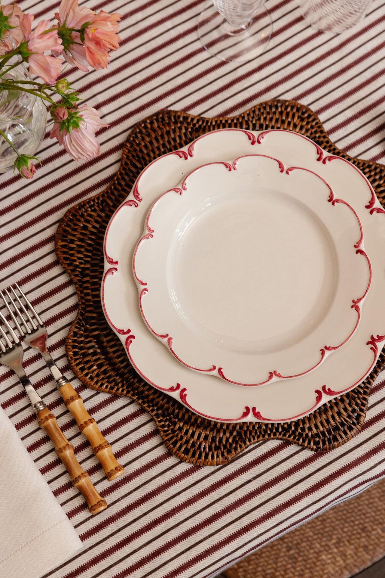 Rebecca Udall Scalloped Wavy Hand Woven Rattan Placemat, Dark Brown with the Olivia Crockery, Raspberry
