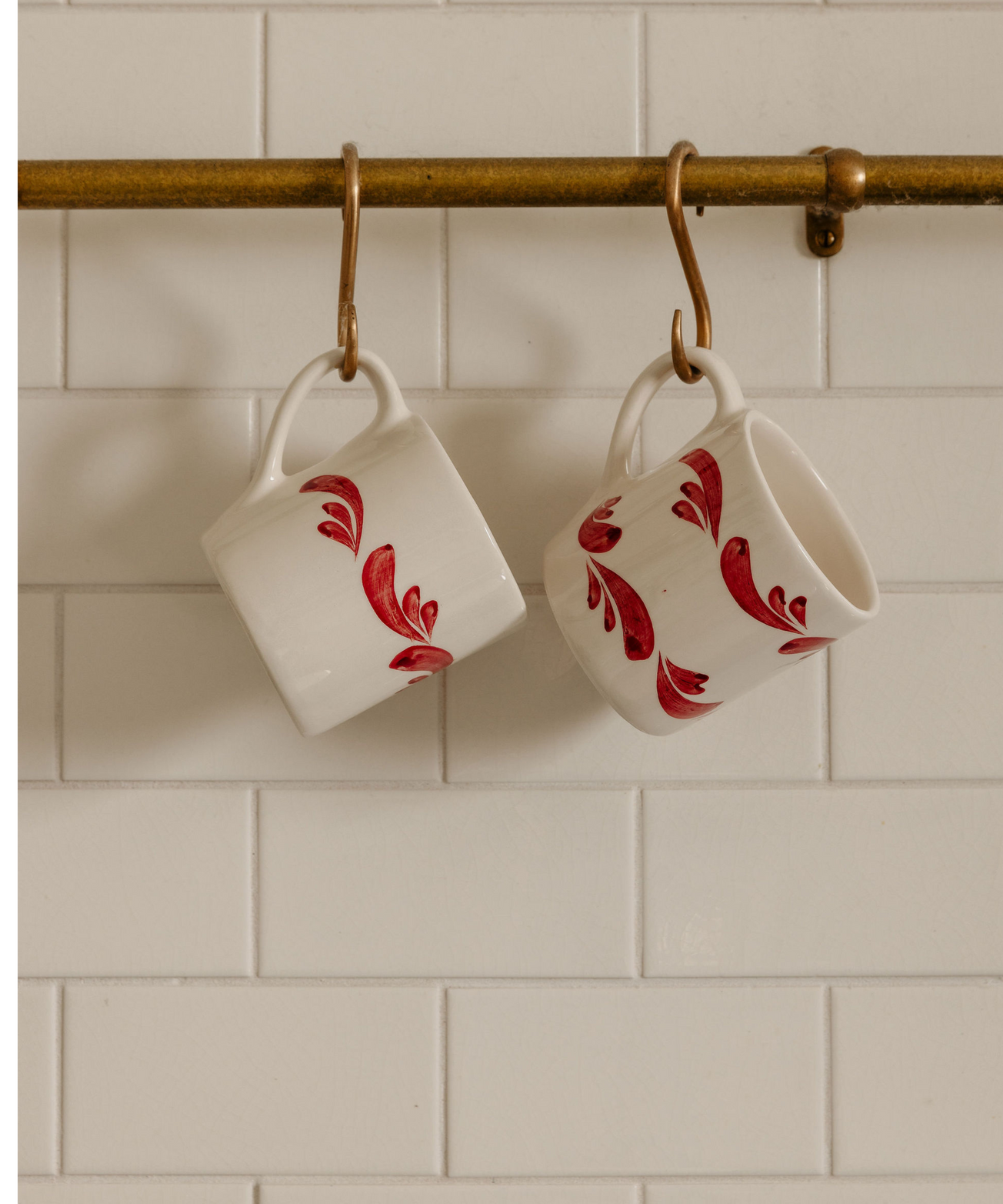 Rebecca Udall Pair of Celia Mugs, Raspberry, Hanging from Hooks in a Kitchen