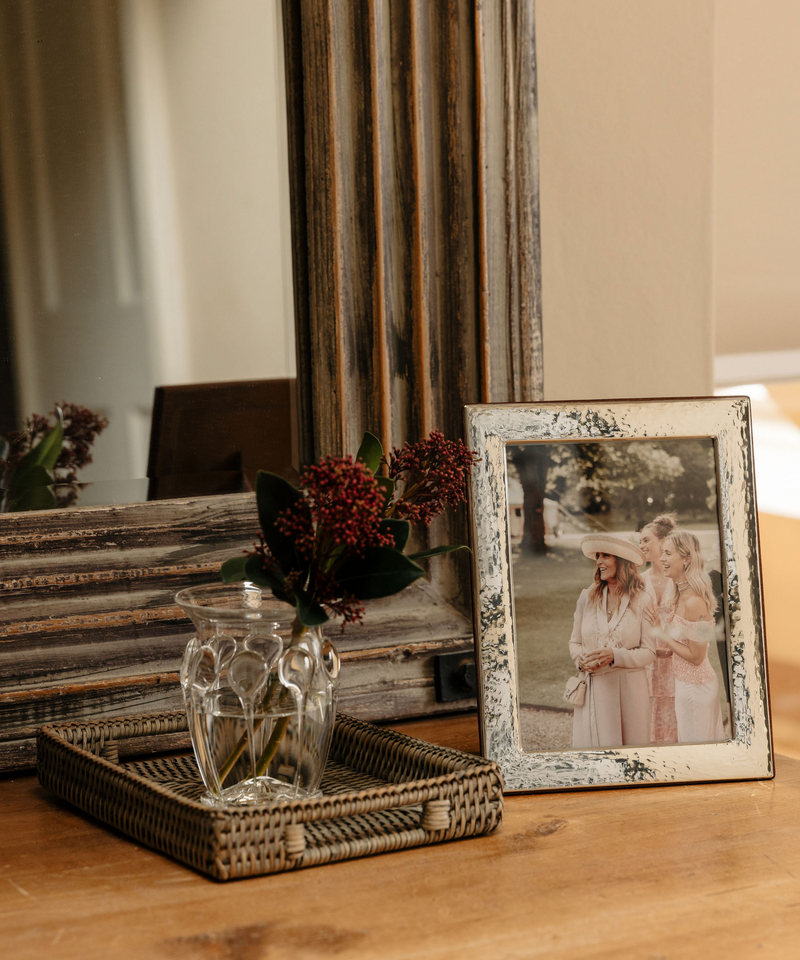 Rebecca Udall Sterling Silver Hammered Photo Frame, displayed next to Pandora Posy Handblown Vase. 